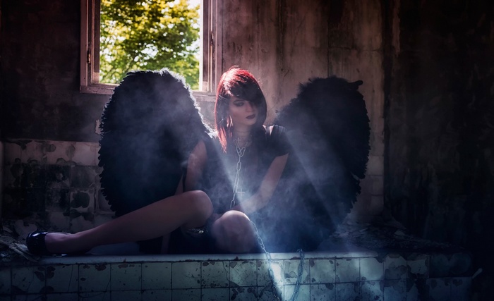Gothic angel with black wings in abandoned building