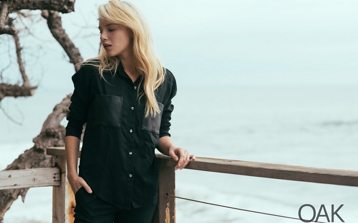 Woman in black shirt and pants by the ocean