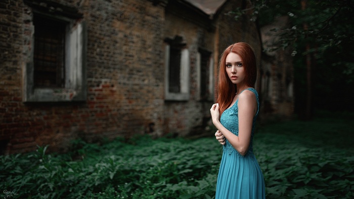 Woman in blue dress in front of old brick building