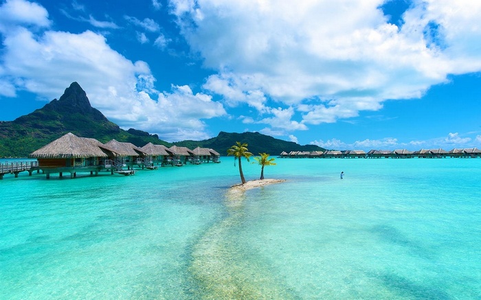 Bora Bora bungalows and Mount Otemanu in turquoise water