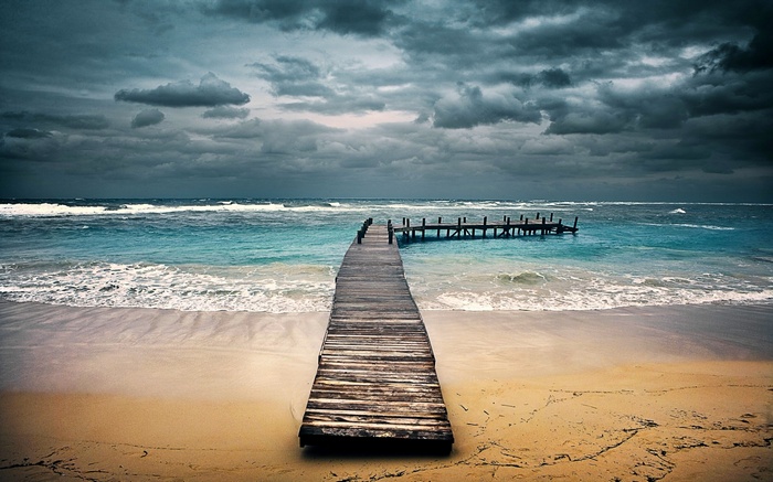 Wooden pier extending into the sea under stormy clouds in Honduras