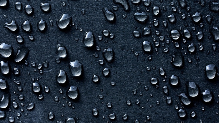 Water drops on a dark textured surface