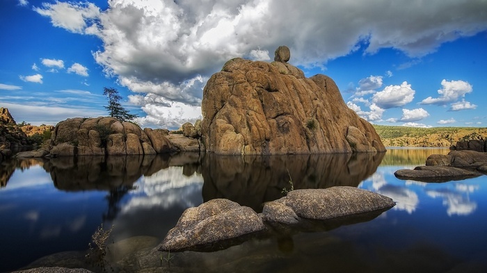 Large rock formations in a lake under a cloudy sky