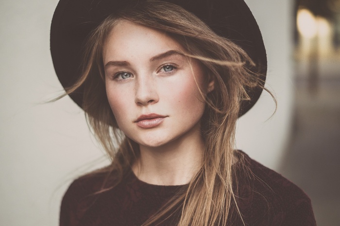 Woman wearing a hat and maroon sweater