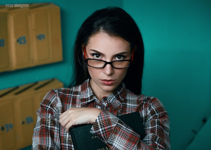 Woman with glasses holding a book