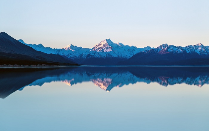Snow-capped mountains reflected in a calm lake