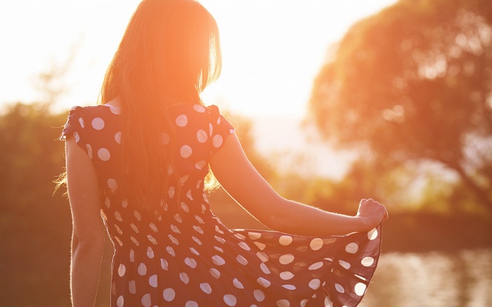 Woman in polka dot dress in sunlight