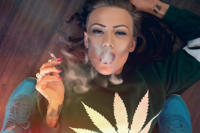 Woman smoking cannabis, exhaling smoke