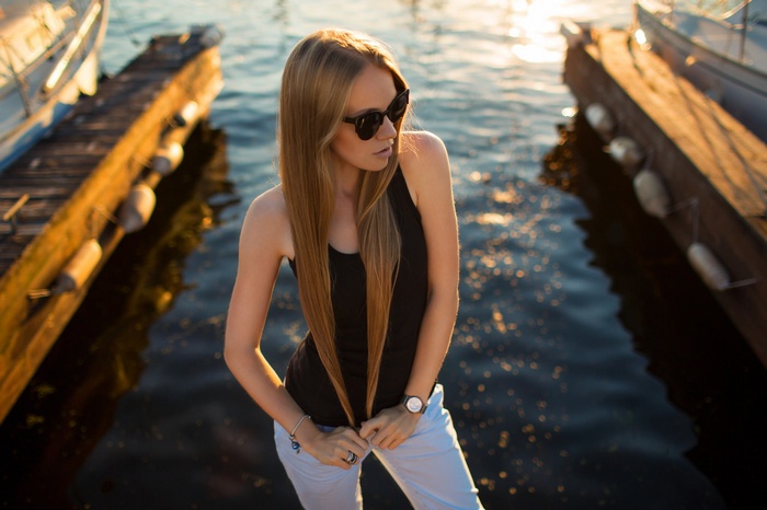 Woman with blonde hair and sunglasses on a dock