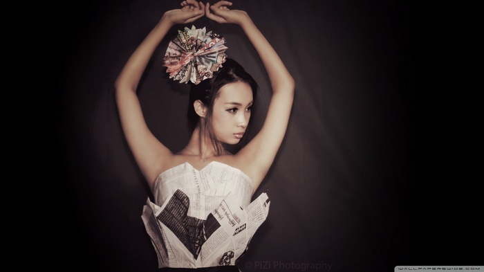 Asian woman in newspaper dress with flower accessory