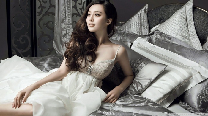 Fan Bingbing in a white dress on a bed