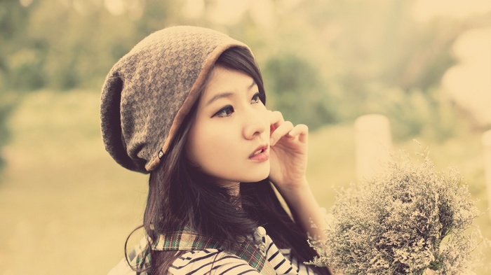 Asian woman wearing a beanie and holding a bouquet