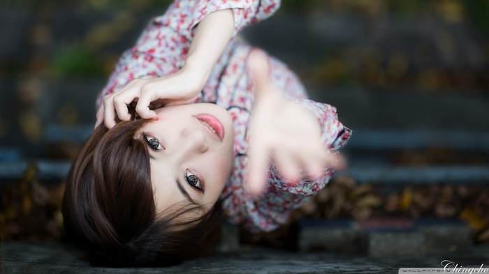 Asian woman with floral shirt reaching out