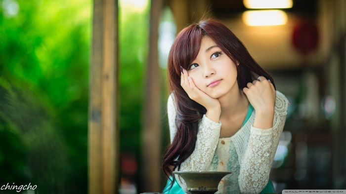 Asian woman resting her head on her hand