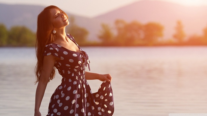 Woman in polka dot dress by the water