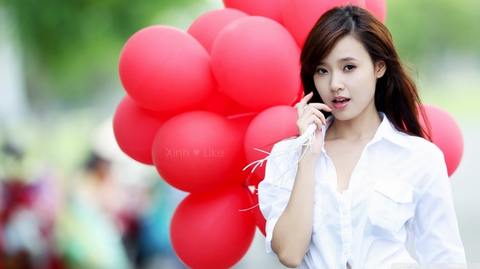 Woman holding red balloons