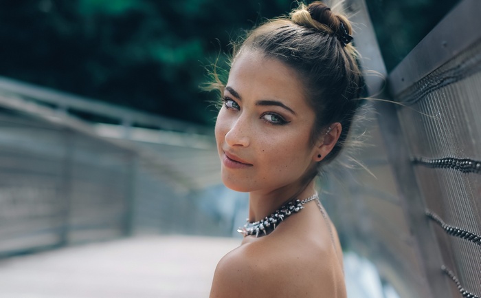 Woman with blue eyes and necklace on a bridge