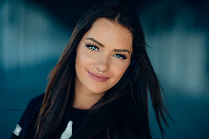 Woman with blue eyes and nose ring smiling