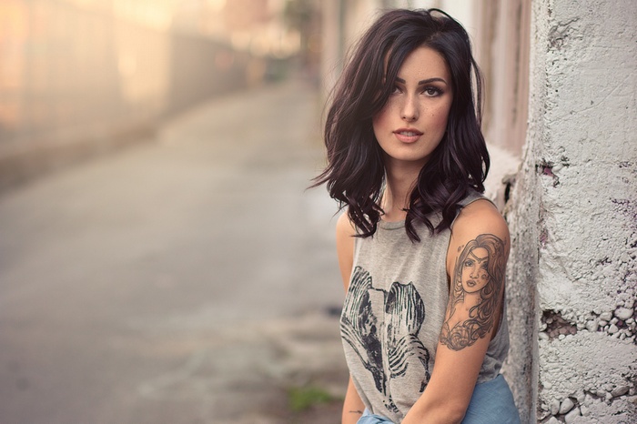 Woman with tattoo and freckles outdoors