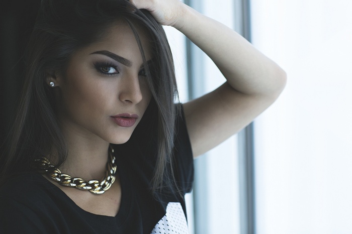 Woman with dark hair and gold necklace