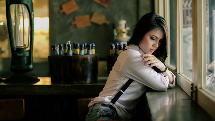 Woman with long hair wearing suspenders and jeans