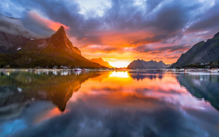 Sunset over a Norwegian fjord with mountains and village