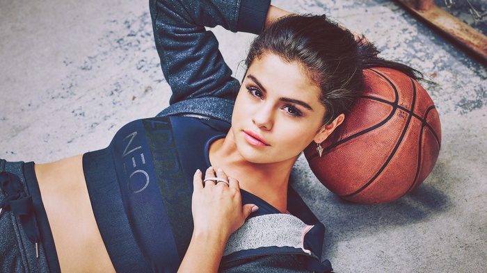Selena Gomez posing with a basketball