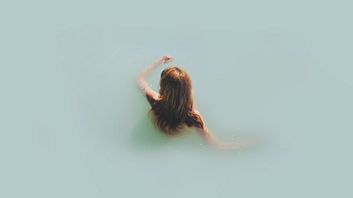 Woman swimming in light blue water