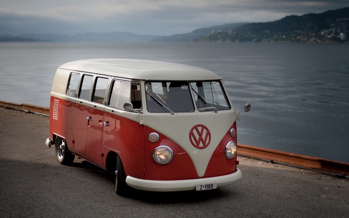 Red and cream Volkswagen Combi by the sea