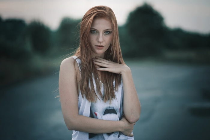 Redhead woman with hand on neck