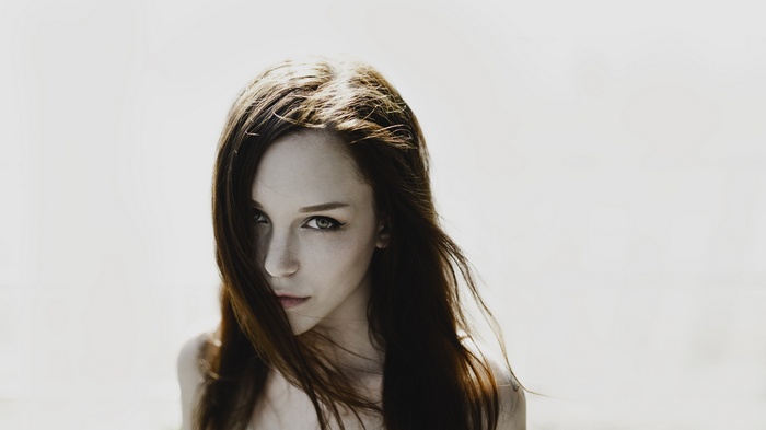 Woman with long brown hair against a white background