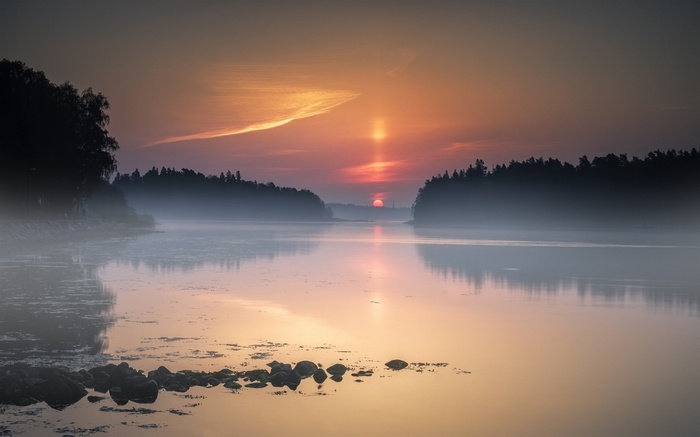 Misty lake at sunset with trees and water reflections