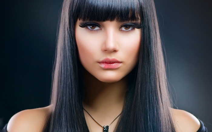 Woman with dark hair and necklace