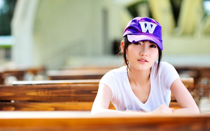 Asian woman wearing a purple hat and white t-shirt