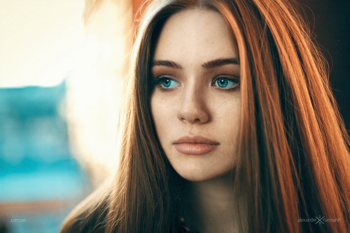 Portrait of a young woman with red hair and blue eyes