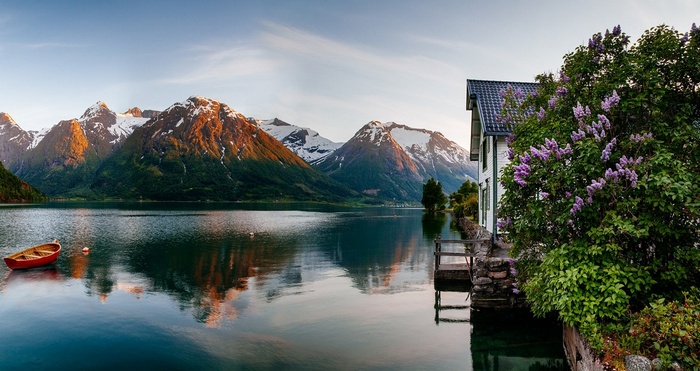 House by a Fjord with Snow-Capped Mountains in Norway
