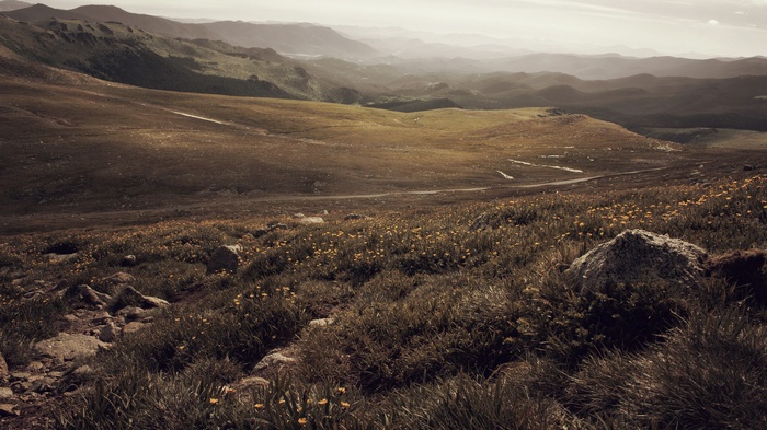 Mountain landscape with rolling hills and a winding road