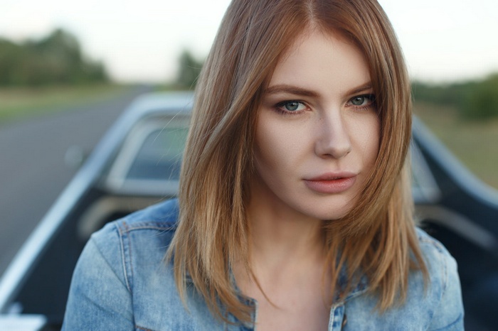 Woman with blonde hair and blue eyes in a denim jacket