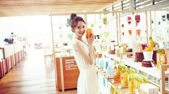 Im Yoona holding oranges in a store