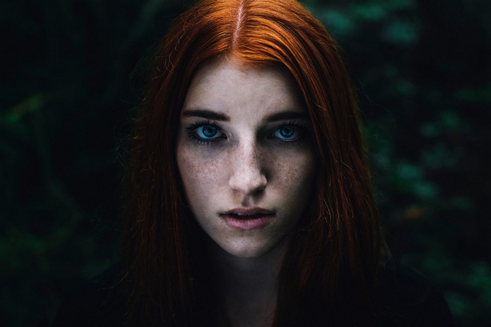 Portrait of a young woman with red hair and freckles