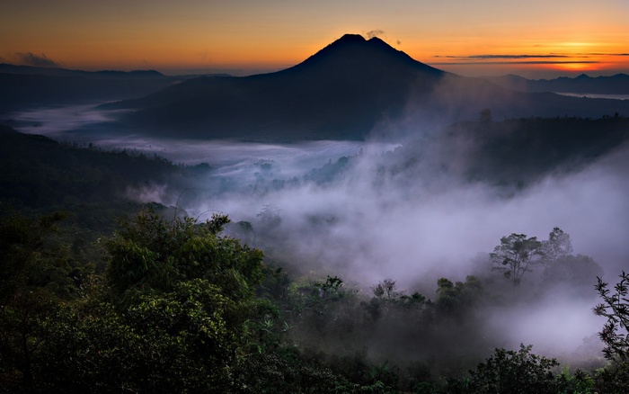 Misty valley and volcano at sunrise in Bali, Indonesia