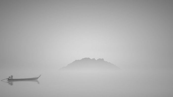 Boat in the mist with island in the background