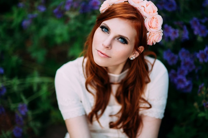 Redhead woman with flower crown in garden