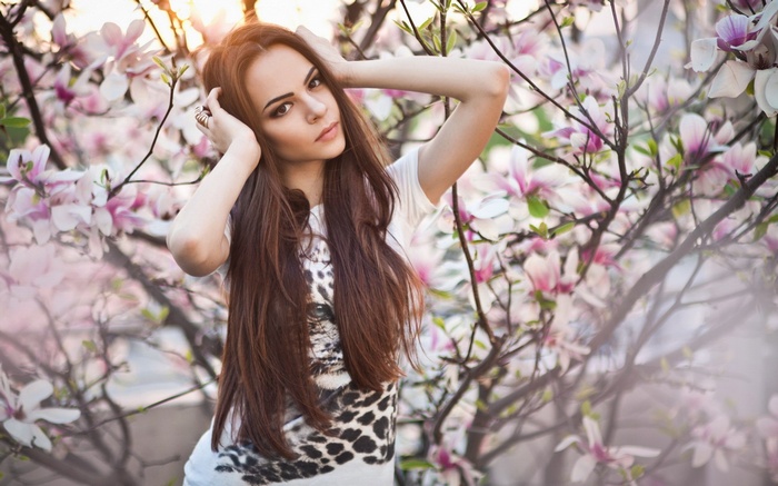 Woman with long brown hair in blooming trees