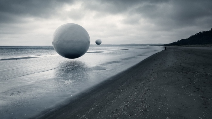 Monochrome beach with floating spheres and a lone figure