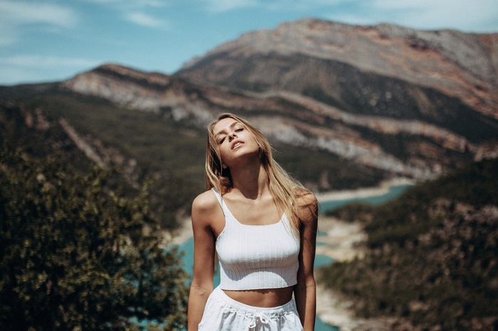 Woman with blonde hair in white top outdoors