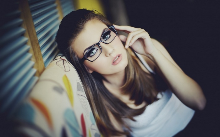 Woman with glasses and blue eyes on a couch