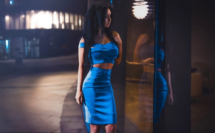 Woman in blue dress by reflective window
