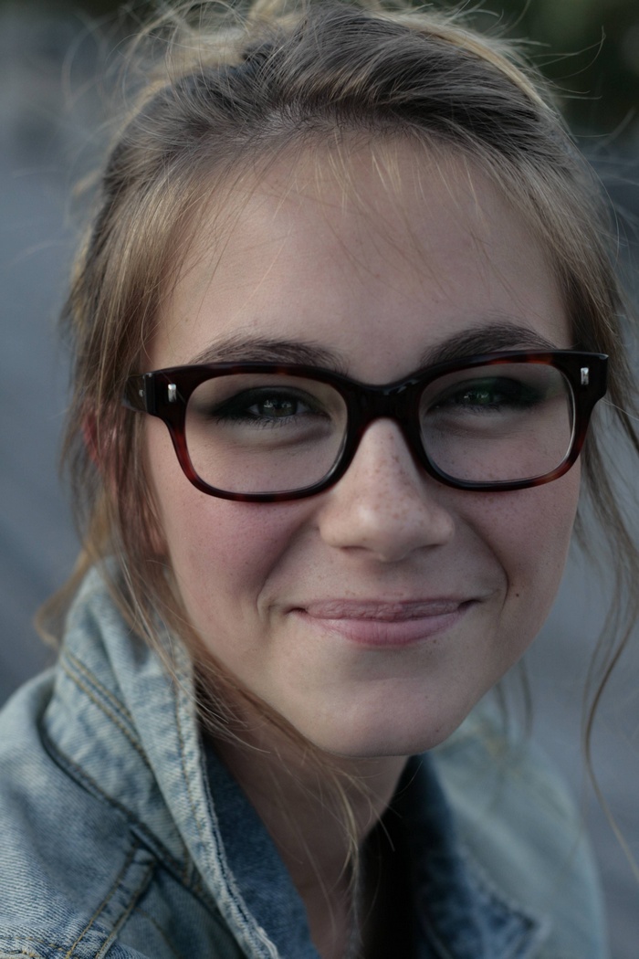 Woman with glasses smiling and looking at viewer