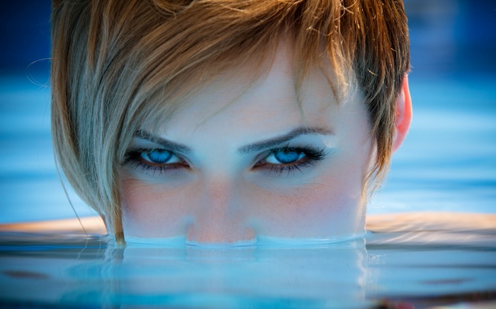 Woman with blue eyes in water